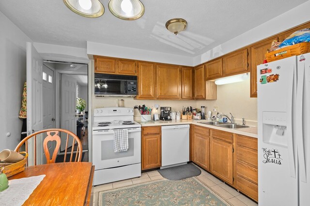 524.526 Rudy Rd, Mansfield, OH 44903 - kitchen featuring white appliances, a sink, light countertops, brown cabinetry, and light tile patterned flooring