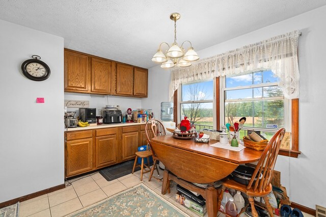 524.526 Rudy Rd, Mansfield, OH 44903 - dining space with a chandelier, light tile patterned floors, and baseboards