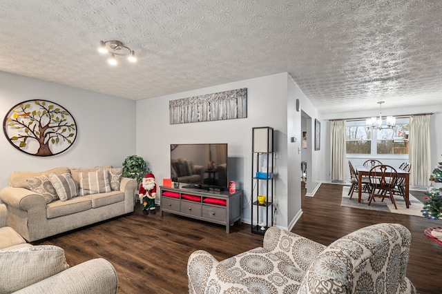 living room featuring a textured ceiling, dark wood-type flooring, and an inviting chandelier