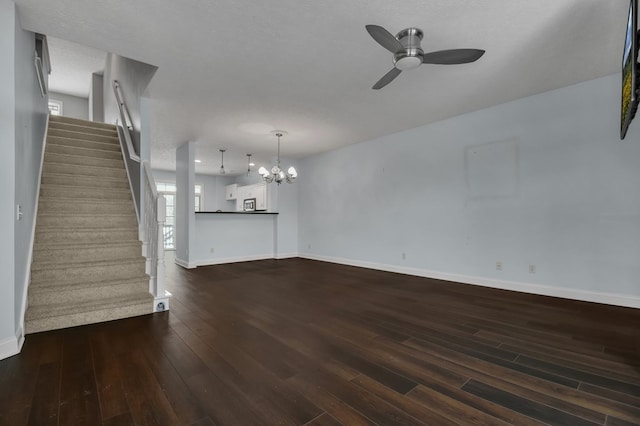 unfurnished living room with a textured ceiling, dark hardwood / wood-style flooring, and ceiling fan with notable chandelier