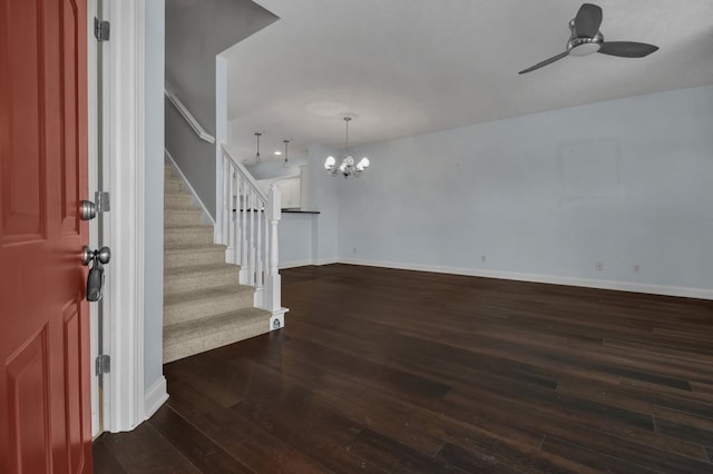 foyer with ceiling fan with notable chandelier and dark hardwood / wood-style flooring