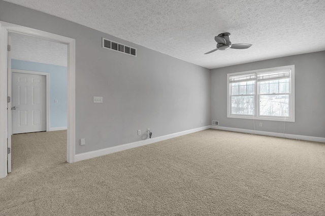 carpeted empty room featuring ceiling fan and a textured ceiling