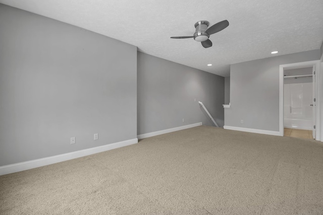 carpeted spare room with a textured ceiling and ceiling fan