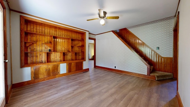 531 Jackson Rd, Galion, OH 44833 - unfurnished living room featuring wallpapered walls, baseboards, wood finished floors, a ceiling fan, and stairway