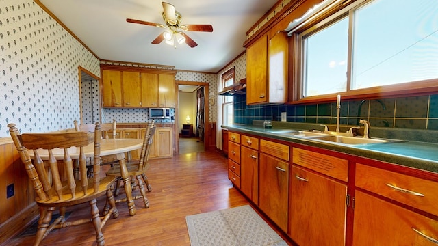 531 Jackson Rd, Galion, OH 44833 - kitchen with wallpapered walls, a sink, stainless steel microwave, light wood-style flooring, and a ceiling fan