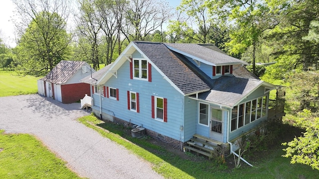 531 Jackson Rd, Galion, OH 44833 - view of home's exterior with roof with shingles, an outdoor structure, a sunroom, a detached garage, and view of wooded area