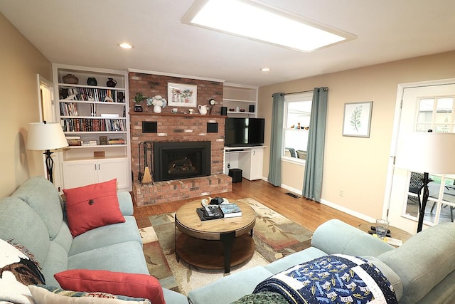 10411 River Rd, Huron, OH 44839 - living room featuring wood finished floors, a brick fireplace, and recessed lighting