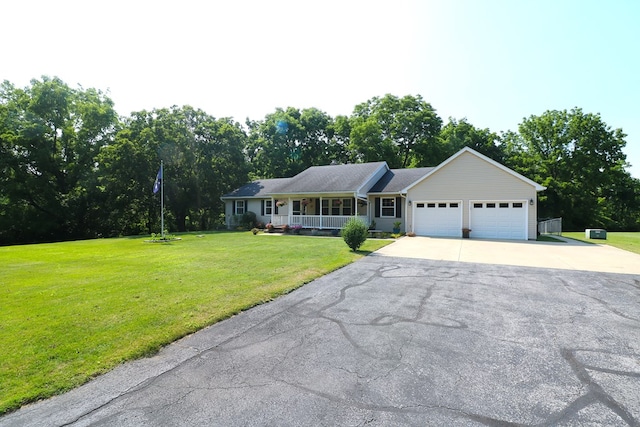 10411 River Rd, Huron, OH 44839 - ranch-style home featuring concrete driveway, a garage, a front yard, and view of wooded area