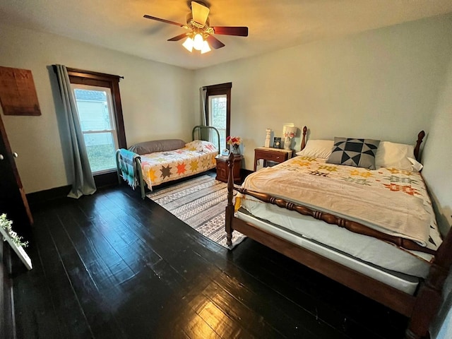 bedroom featuring ceiling fan, multiple windows, and hardwood / wood-style flooring