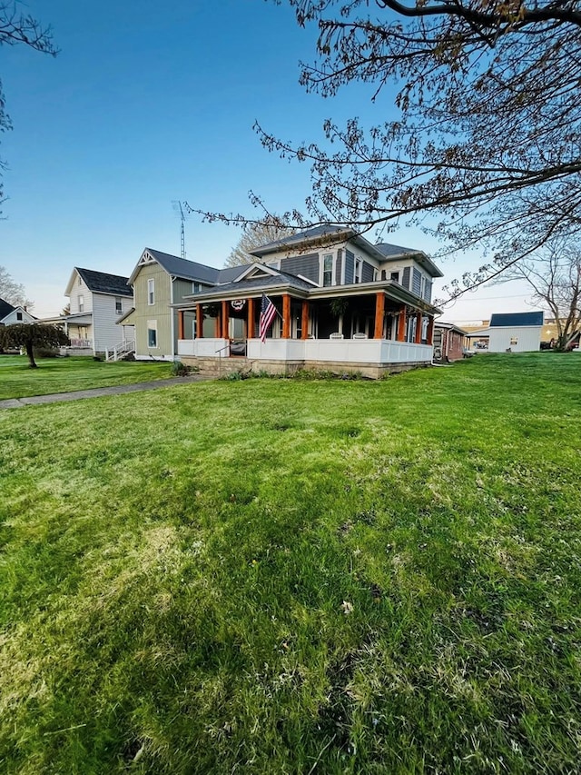 rear view of property featuring a lawn and a sunroom