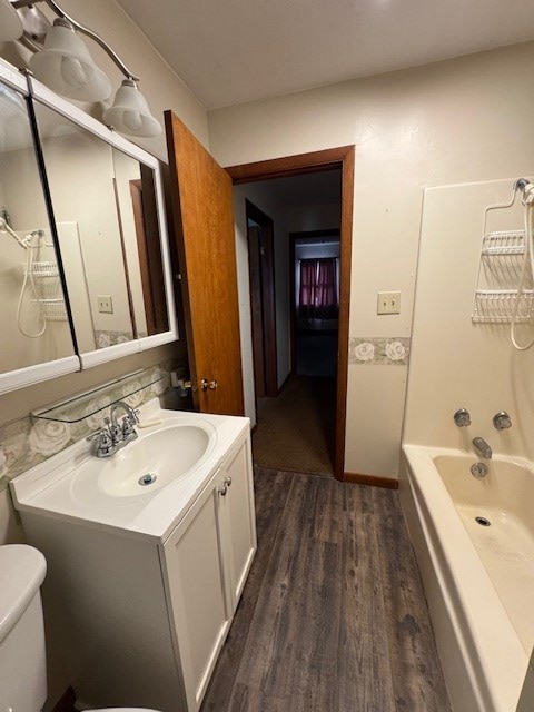 full bathroom featuring vanity, hardwood / wood-style floors, bathing tub / shower combination, and toilet