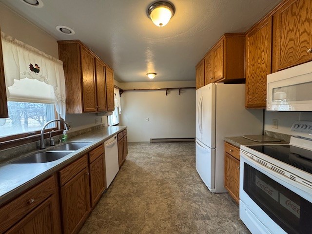 kitchen with a baseboard radiator, sink, and white appliances