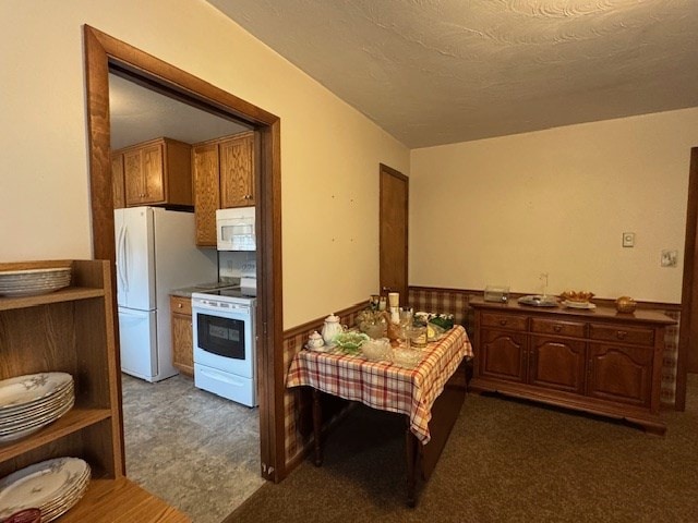 kitchen with dark carpet and white appliances