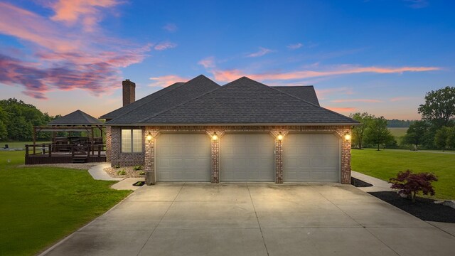 1439 Township Rd Unit 1238, Ashland, OH 44805 - property exterior at dusk featuring a gazebo, concrete driveway, an attached garage, brick siding, and a yard