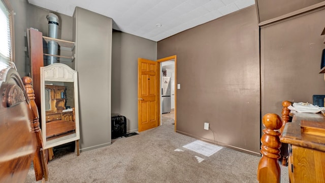 bedroom featuring light carpet, stainless steel refrigerator, and a closet