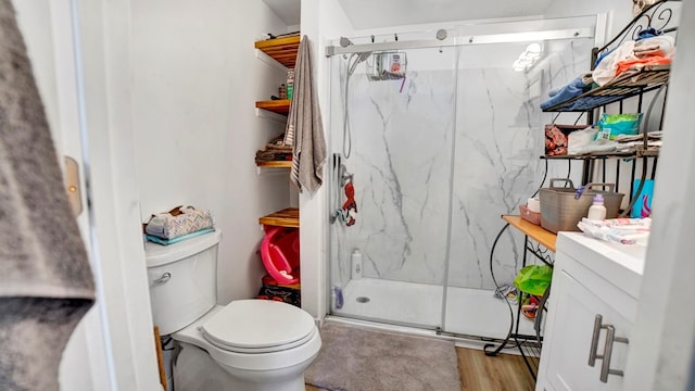 bathroom featuring hardwood / wood-style floors, vanity, toilet, and a shower with door