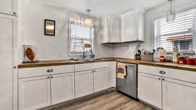 kitchen featuring butcher block counters, white cabinetry, dishwasher, and pendant lighting