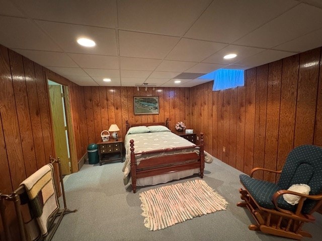 bedroom with carpet floors and wood walls