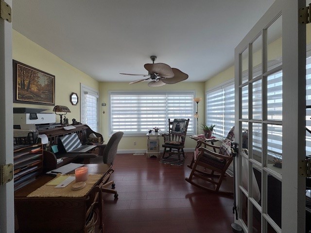 office space featuring dark wood-type flooring, a wealth of natural light, and ceiling fan