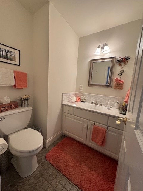 bathroom with vanity, backsplash, and toilet