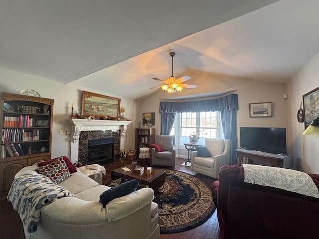 living room featuring vaulted ceiling, hardwood / wood-style floors, ceiling fan, and a fireplace