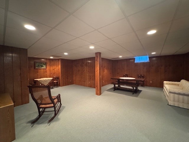 rec room featuring light colored carpet, wood walls, and a drop ceiling