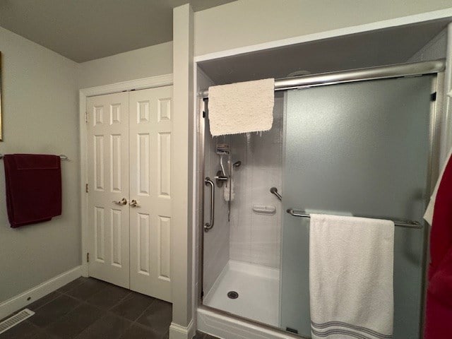 bathroom featuring a shower with shower door and tile patterned flooring