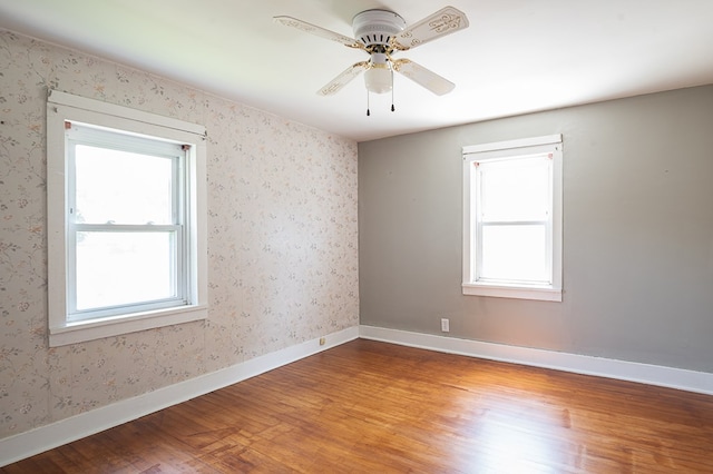 spare room with hardwood / wood-style flooring, plenty of natural light, and ceiling fan