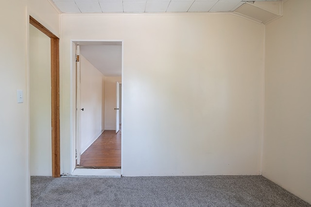 carpeted empty room with lofted ceiling