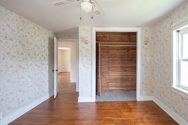 unfurnished bedroom featuring ceiling fan, a closet, and hardwood / wood-style flooring