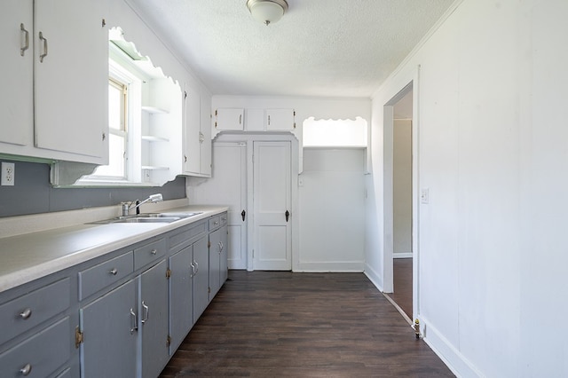 kitchen with a textured ceiling, dark wood-type flooring, sink, gray cabinets, and white cabinetry