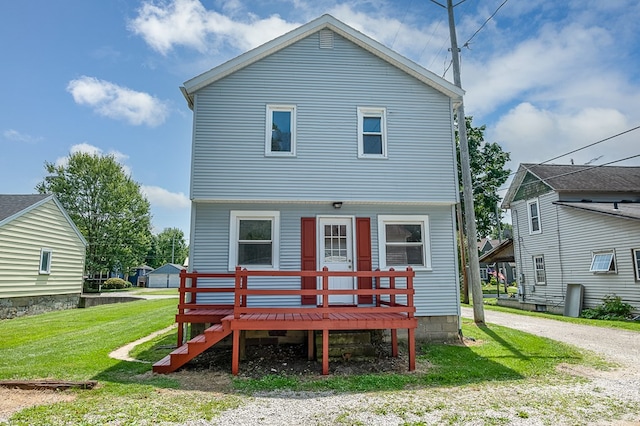 back of property featuring a lawn and a deck