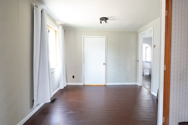 empty room featuring dark hardwood / wood-style flooring and ornamental molding