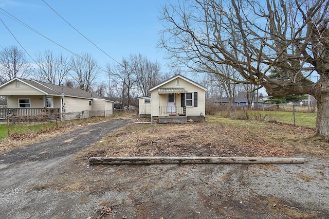 bungalow featuring driveway and fence