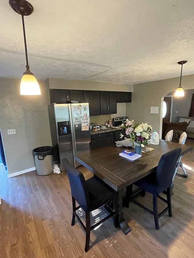 dining space with a textured ceiling and light wood-type flooring