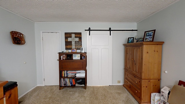 misc room featuring a textured ceiling, crown molding, a barn door, and carpet flooring