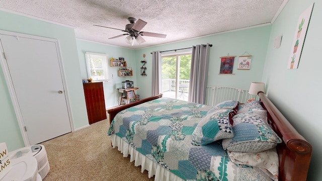 carpeted bedroom featuring ceiling fan, access to outside, a textured ceiling, ornamental molding, and a closet