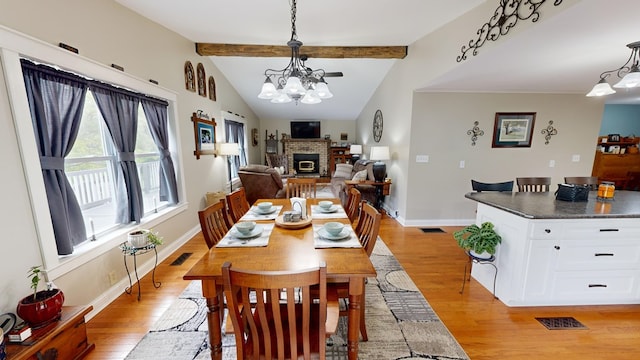 dining room with light hardwood / wood-style floors, lofted ceiling with beams, and a notable chandelier