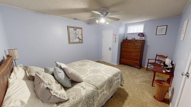 bedroom featuring ceiling fan, a textured ceiling, and light carpet