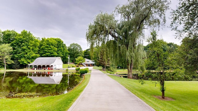 view of community with a lawn and a water view