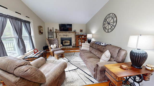 living room featuring a brick fireplace and vaulted ceiling