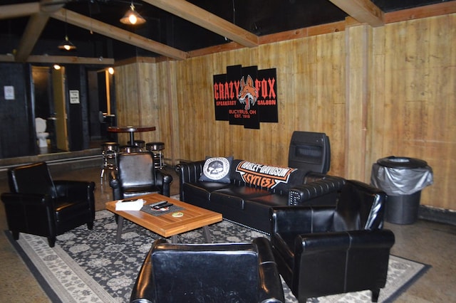 living room featuring beamed ceiling and wood walls