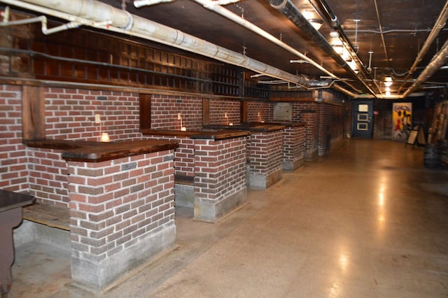 bar featuring concrete floors and brick wall