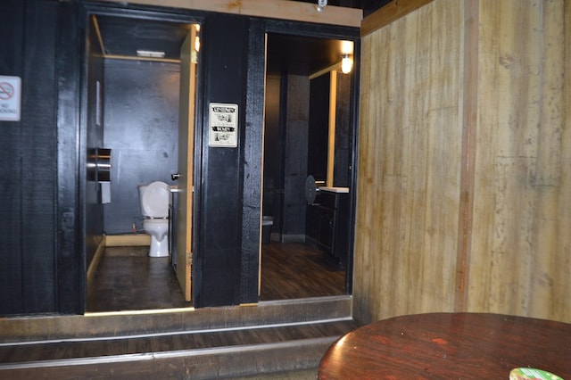 bathroom with wooden walls and toilet