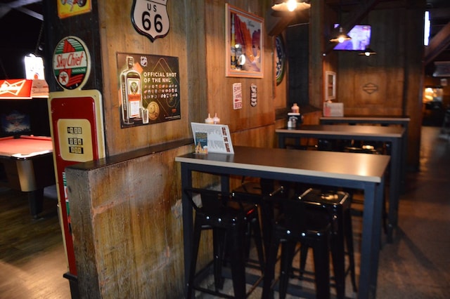 bar with wood walls and hardwood / wood-style flooring