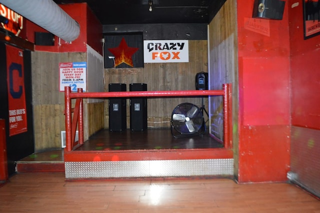 bar with wood walls and hardwood / wood-style flooring