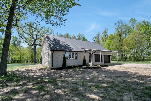 5616 Windfall Rd, Galion, OH 44833 - view of front of home featuring driveway, brick siding, metal roof, and an attached garage