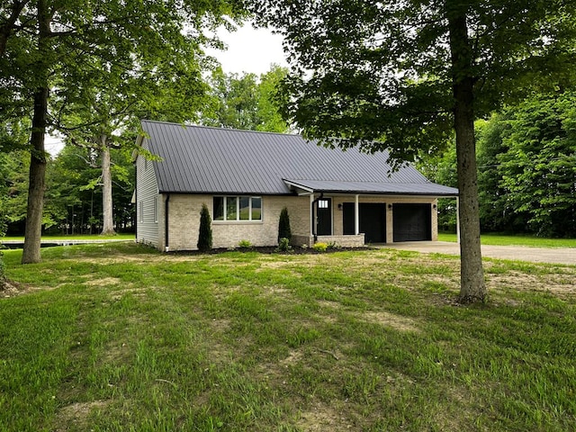5616 Windfall Rd, Galion, OH 44833 - view of front of house with metal roof, a garage, driveway, and a front lawn
