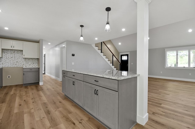 5616 Windfall Rd, Galion, OH 44833 - kitchen with gray cabinets, light wood finished floors, decorative backsplash, decorative light fixtures, and baseboards