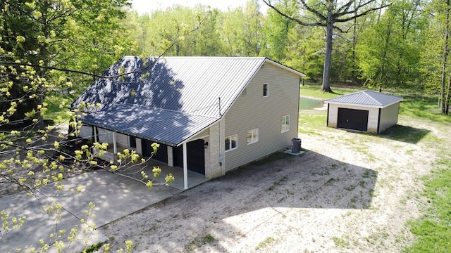 5616 Windfall Rd, Galion, OH 44833 - view of front of house with an outbuilding, metal roof, a view of trees, and a garage